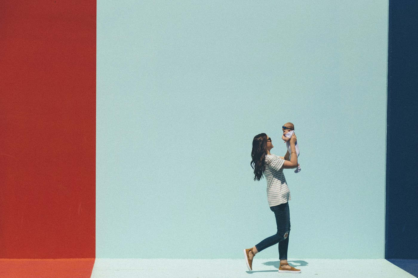 A parent lifting her little one into the air